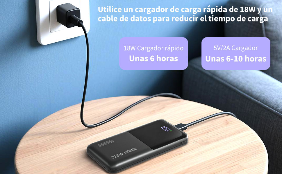 El texto muestra los tiempos de carga: «Hasta 8-26 horas» y «USB6». Dispositivo de carga o banco de energía negro sobre una superficie de madera sobre un fondo de pared azul.