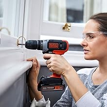 woman drills into window frame with black+decker drill