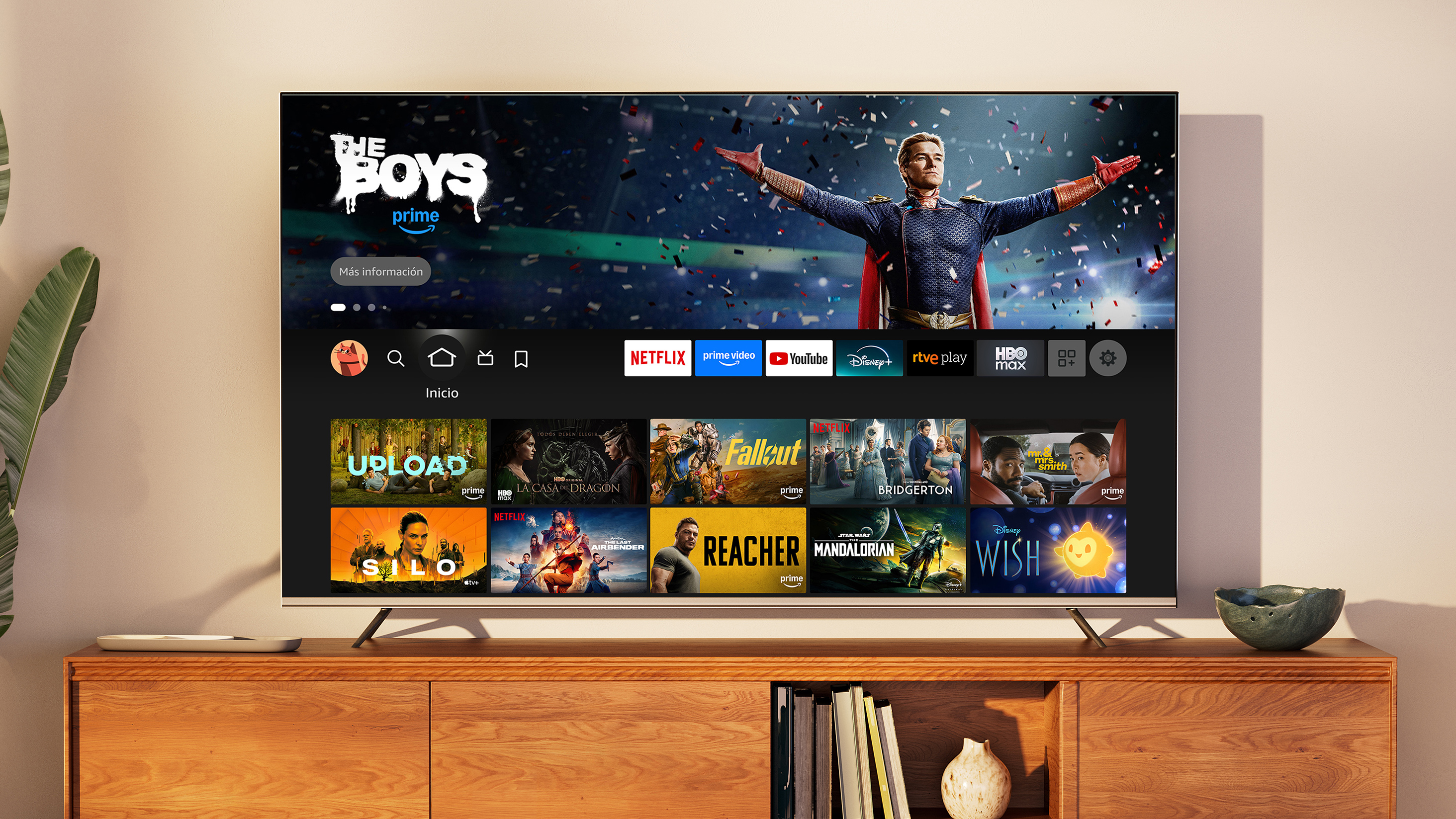 Primer plano de un Fire TV en el salón durante el día. El menú principal del Fire TV está en pantalla, con Los amos del aire como título seleccionado.
