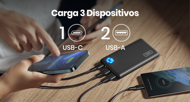 una persona que sostiene un cargador con un puerto usb - c sobre la mesa.