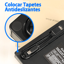 Primer plano de un dispositivo electrónico negro con el texto «Colocar Tapetes Antideslizantes» (Coloque alfombrillas antideslizantes). El círculo azul resalta una característica específica.