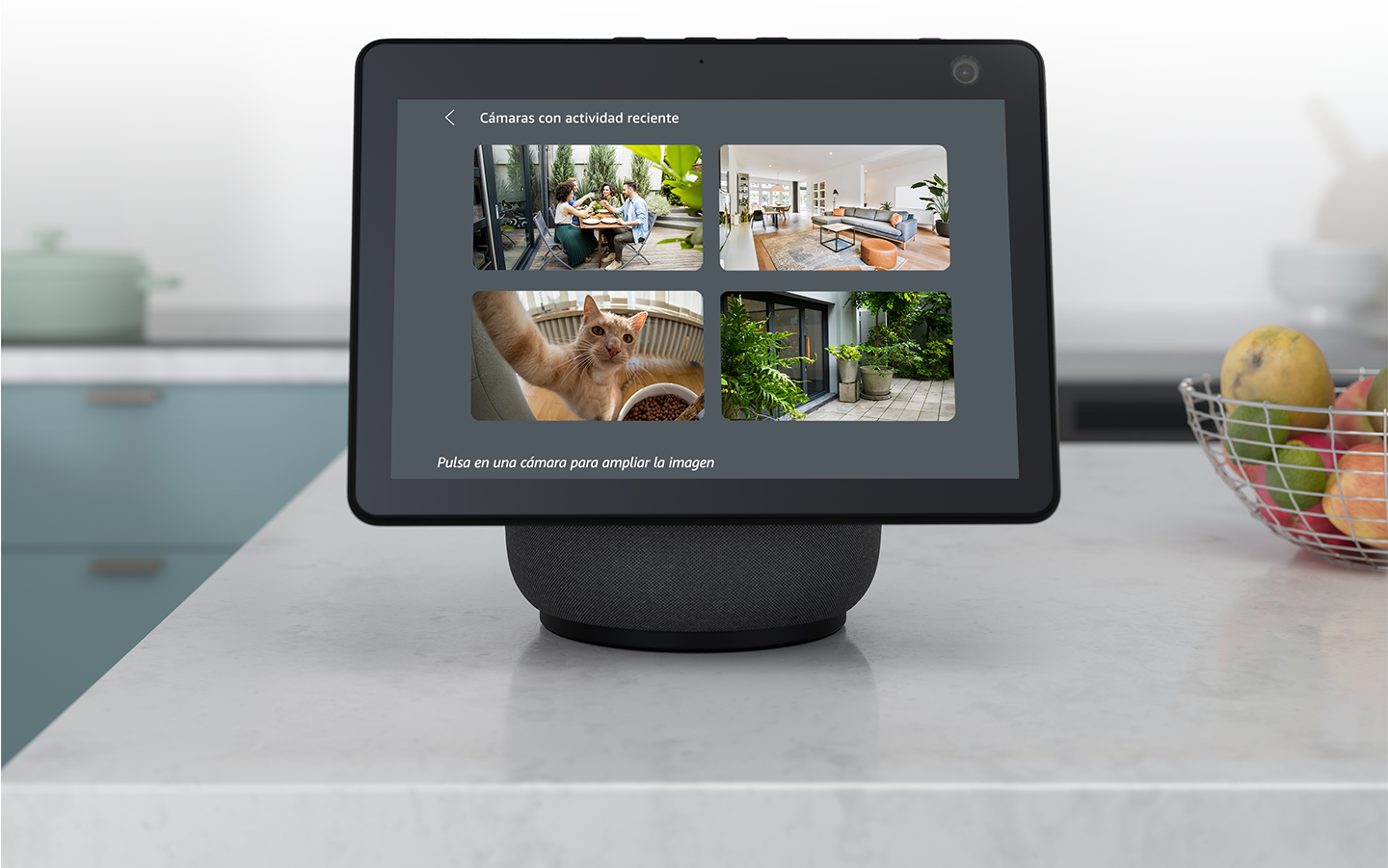 Un Echo Show situado en la encimera de una cocina muestra simultáneamente cuatro imágenes de vídeo en directo de la cámara Blink.