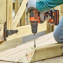 Un hombre perfora madera con un taladro BLACK+DECKER