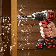 Una persona perforando una viga de madera con un taladro BLACK+DECKER.